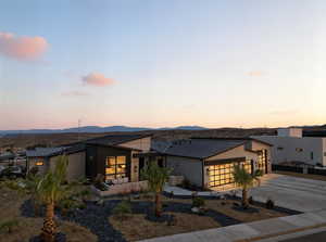 View of front of house with a garage, stucco siding, concrete driveway, a metal roof, and a standing seam roof