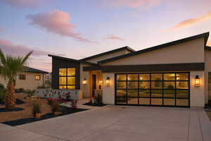 Modern home with an attached garage, driveway, and stucco siding