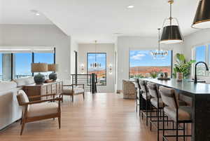 Dining room with a chandelier, light wood finished floors, and recessed lighting
