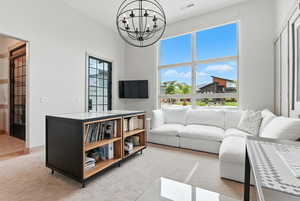 Living area featuring light carpet and a chandelier