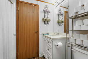 Bathroom with vanity, a shower with shower curtain, dark wood-style floors, and a textured ceiling