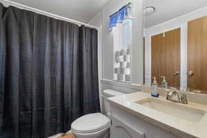 Bathroom with a textured ceiling, vanity, and a shower with curtain