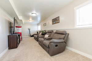Living area with light colored carpet and a textured ceiling