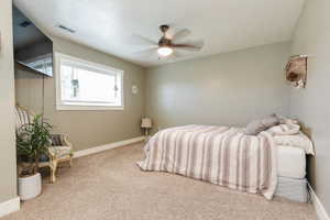 Carpeted bedroom with baseboards and a ceiling fan