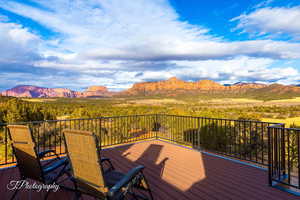 Wooden deck featuring a mountain view and a view of trees