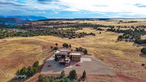 Aerial view of property and surrounding area featuring a mountain backdrop