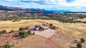 Aerial view of property and surrounding area featuring a mountainous background
