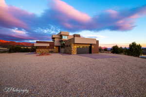 View of front of home featuring stone siding, stucco siding, an attached garage, and driveway