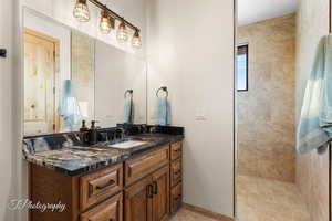 Bathroom featuring vanity and a tile shower