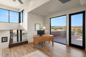 Home office featuring plenty of natural light, wood finished floors, and recessed lighting