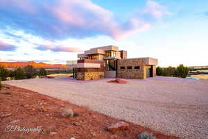Contemporary home with stone siding, driveway, stucco siding, and a mountain view