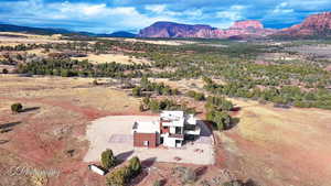 Aerial view of property and surrounding area featuring a mountainous background