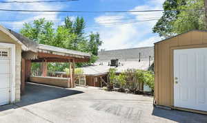 View of back of home, carport with attached workshop, and work shed