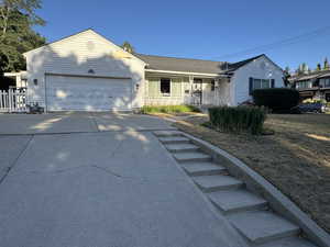 Ranch-style house with driveway, a garage, and a porch