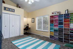 Bedroom featuring dark carpet, a desk, lofted ceiling, a closet, and ceiling fan