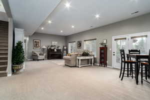 Living room featuring light colored carpet, stairway, and recessed lighting