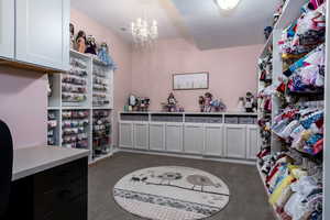 Spacious room featuring carpet and a chandelier