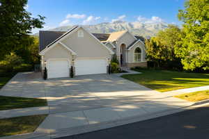 View of front facade with a mountain view, a garage, roof mounted solar panels, and room for a small RV on the side