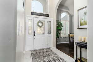 Foyer featuring arched walkways and light tile patterned flooring
