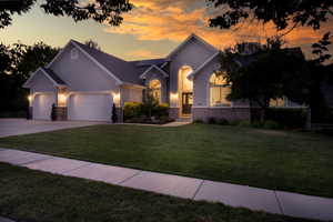 View of front of property featuring a front lawn, stucco siding, a garage, and concrete driveway