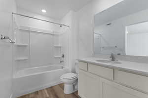 Bathroom featuring shower / bathtub combination, light wood-type flooring, and vanity