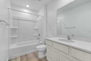 Bathroom with shower / washtub combination, light wood-style flooring, and vanity