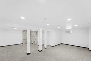 Below grade area with light carpet and recessed lighting
