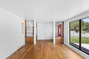Unfurnished room with wood finished floors and baseboards