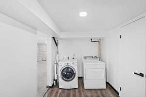 Laundry area with dark wood-style flooring and separate washer and dryer