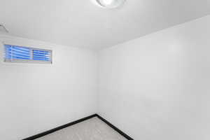 Spare room with a textured ceiling and light carpet