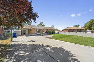 Single story home featuring driveway, a carport, and brick siding