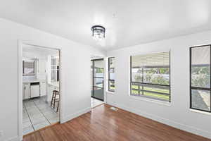 Spare room featuring healthy amount of natural light and light wood-type flooring