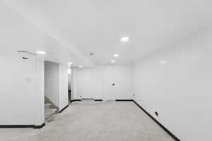 Finished basement with carpet, wooden walls, and recessed lighting