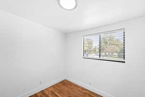 Spare room featuring baseboards and wood finished floors