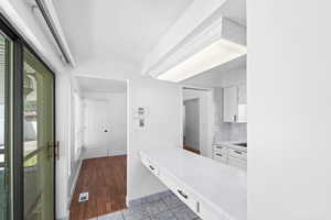 Kitchen featuring white cabinetry and dark tile patterned floors