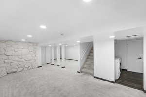 Finished basement featuring carpet, recessed lighting, and stairs