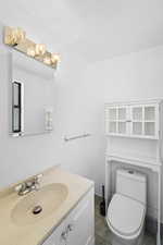 Half bath with vanity and dark tile patterned floors