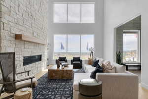 Living area with wood finished floors, a fireplace, and a high ceiling