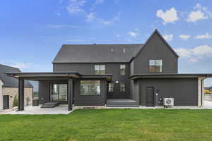 Rear view of property with a patio area, stucco siding, and a lawn