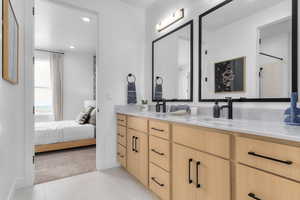 Ensuite bathroom with double vanity, recessed lighting, light tile patterned floors, and a shower