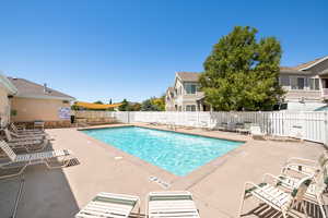 Community pool with a patio area and a residential view