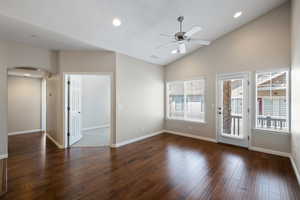 Unfurnished room with arched walkways, vaulted ceiling, dark wood-type flooring, recessed lighting, and a ceiling fan