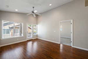 Spare room featuring dark wood-style flooring, a towering ceiling, a ceiling fan, and recessed lighting