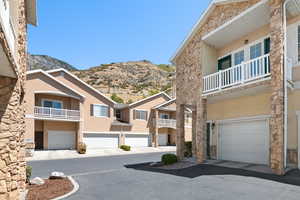 Exterior space with a garage, a balcony, a mountain view, and driveway