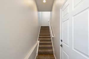 Stairway with tile patterned flooring and recessed lighting
