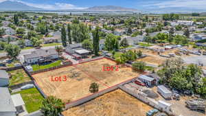 Aerial perspective of suburban area with a mountain backdrop and property parcel outlined
