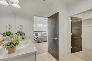 Bathroom featuring vanity, ensuite bath, light tile patterned flooring, and ceiling fan