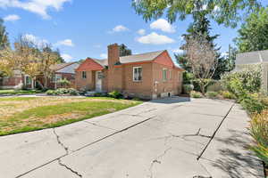 View of front of house featuring a chimney and brick siding