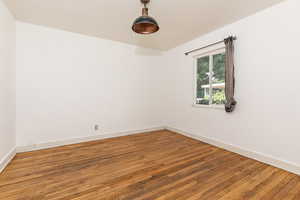 Empty room featuring hardwood / wood-style flooring and baseboards