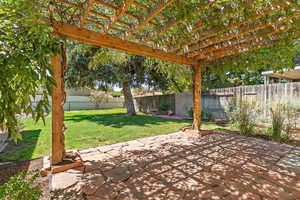 Fenced backyard with a pergola and a patio